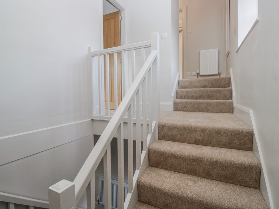 A staircase with carpet and handrail at Jubilee in Graythwaite near Hawkshead