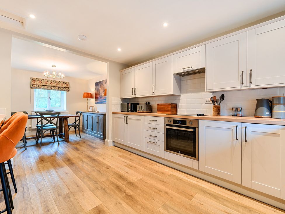 A kitchen with cabinets and a table at Jubilee at the Graythwaite Estate Graythwaite near Hawkshead