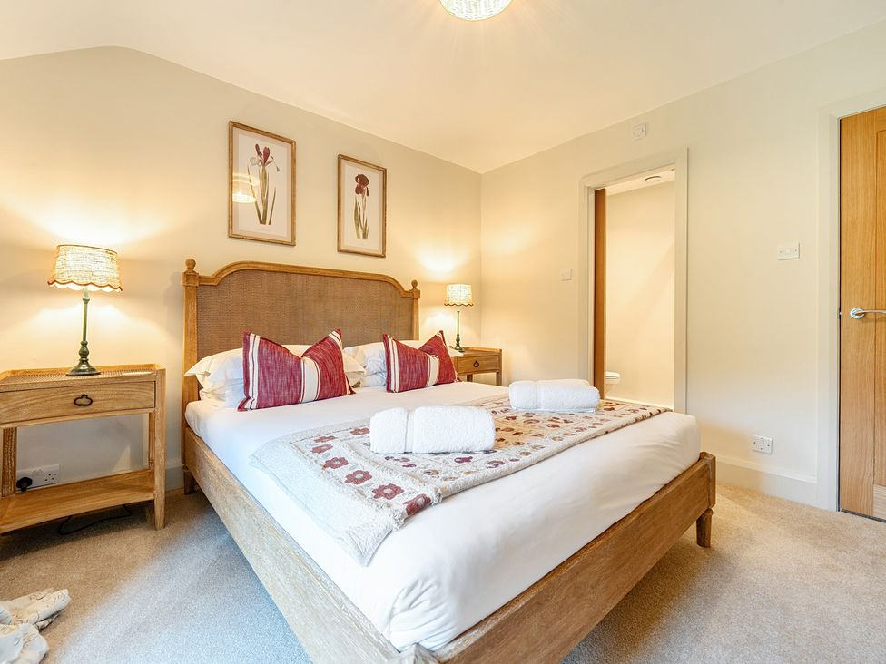 A bedroom with a bed and nightstand at Jubilee at the Graythwaite Estate near Hawkshead