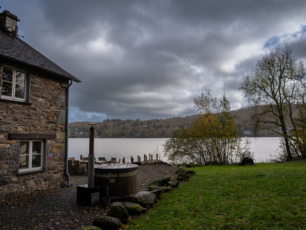 An outdoor area with a hot tub near a lake at Hammerhole in Graythwaite near Hawkshead