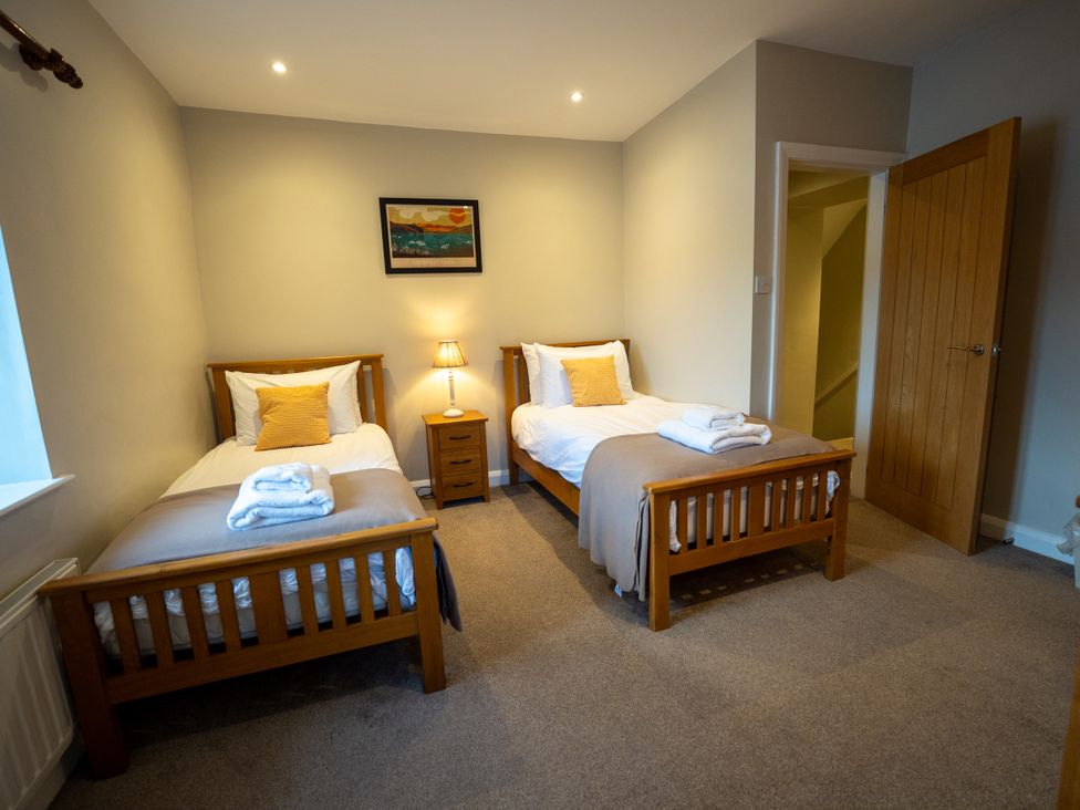 A bedroom with two single beds and a nightstand at Hammerhole in Graythwaite near Hawkshead