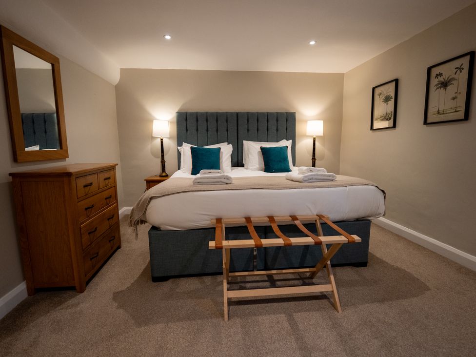 A bedroom with a bed and dresser at Hammerhole in Graythwaite near Hawkshead