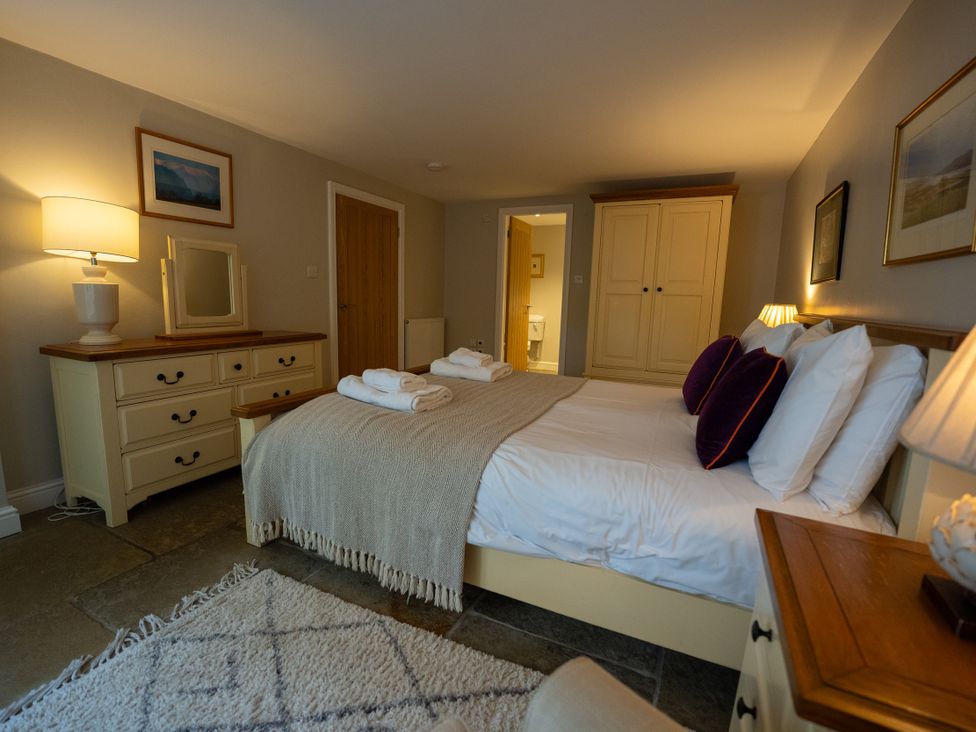 A bedroom with a bed and dresser at Hammerhole in Graythwaite near Hawkshead