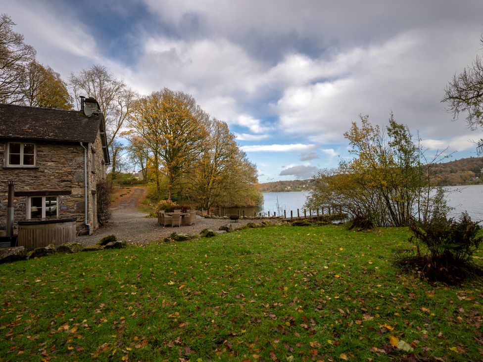 A house by a lake with trees and grass at Hammerhole in Graythwaite near Hawkshead