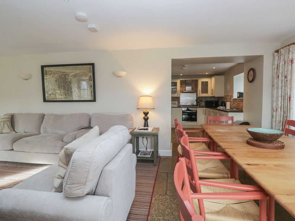 A living room with a sofa and dining area at Hammerhole in Graythwaite near Hawkshead