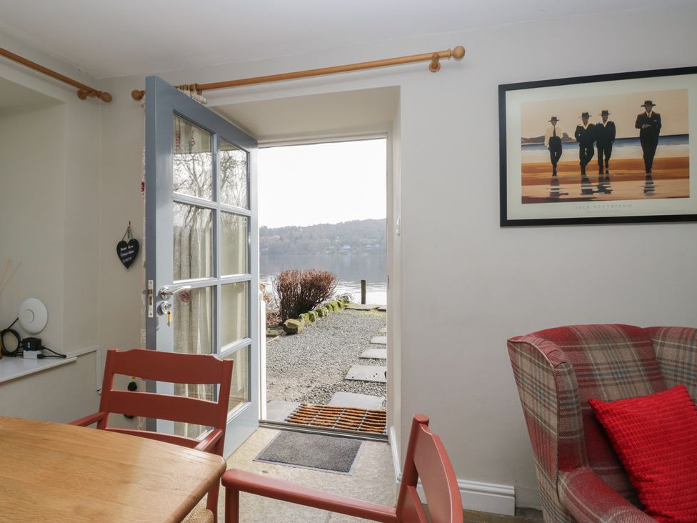 A dining room with an open door leading to a view at Hammerhole in Graythwaite near Hawkshead