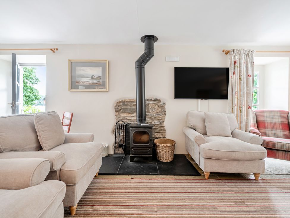 A living room with a fireplace and seating area at Hammerhole at the Graythwaite Estate near Hawkshead