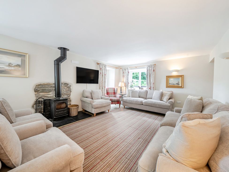 A living room with sofas and a fireplace at Hammerhole at the Graythwaite Estate near Hawkshead