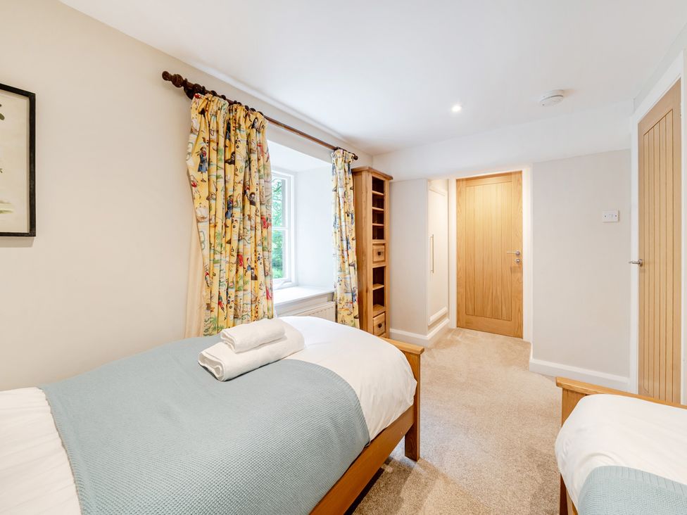 A bedroom with two beds and a window at Hammerhole at the Graythwaite Estate near Hawkshead