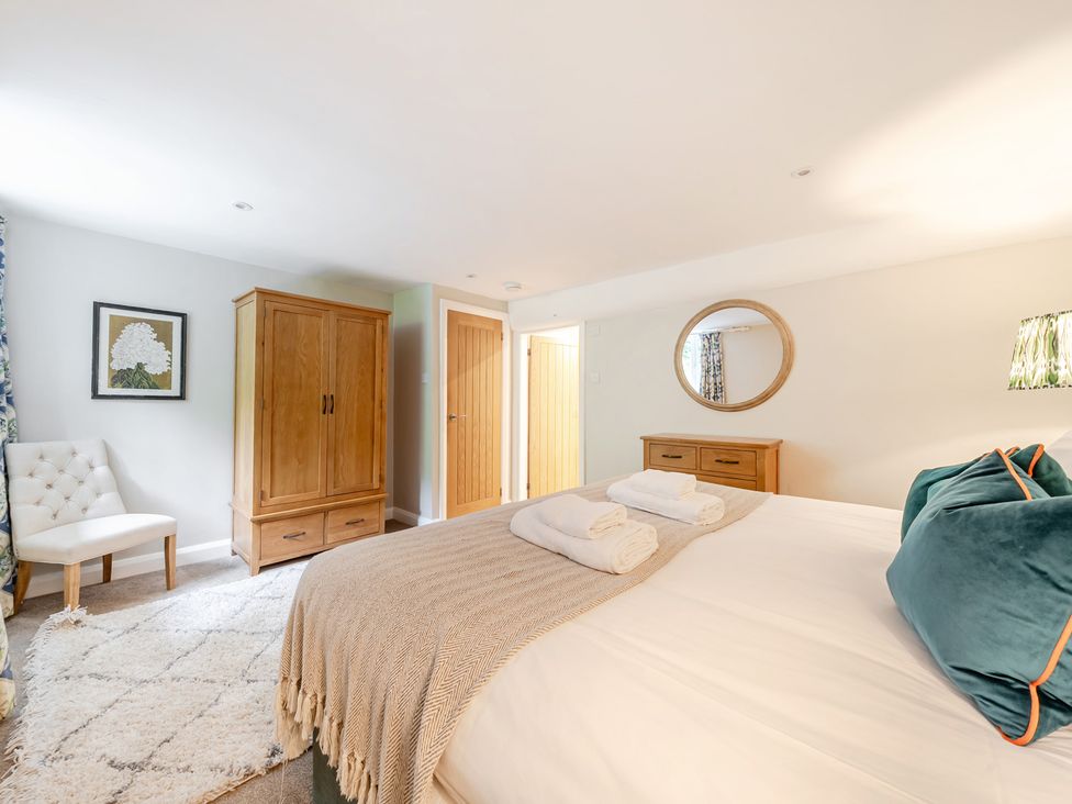 A bedroom with a bed and wardrobe at Hammerhole at the Graythwaite Estate near Hawkshead
