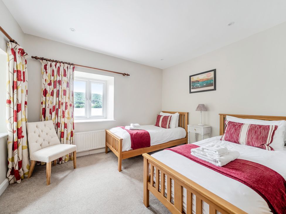 A bedroom with two beds and a window at Hammerhole at the Graythwaite Estate near Hawkshead