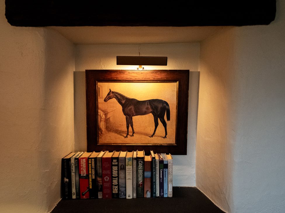 A nook with a painting and a shelf of books at Hullet Hall Graythwaite near Hawkshead