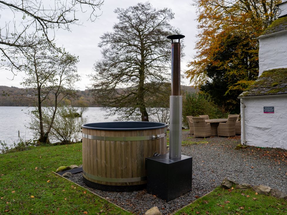 A hot tub and seating area by the lake at Hullet Hall in Graythwaite near Hawkshead