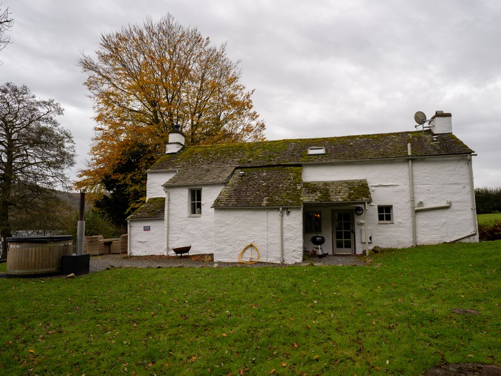 An outdoor view of a house with a hot tub at Hullet Hall in Graythwaite near Hawkshead