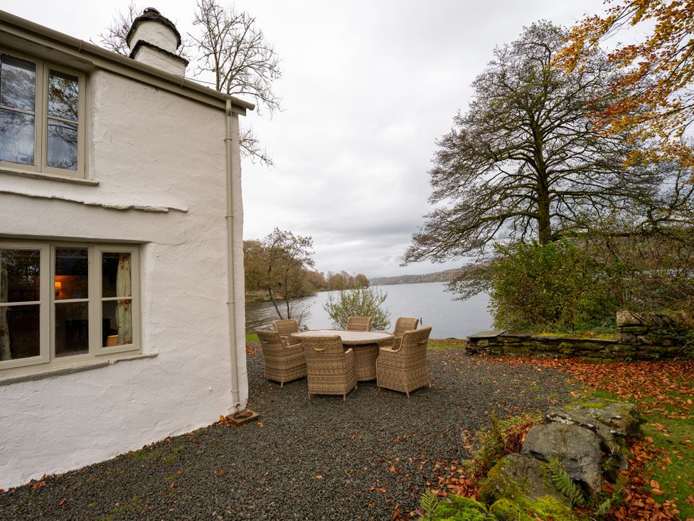 An outdoor seating area by a lake at Hullet Hall in Graythwaite near Hawkshead