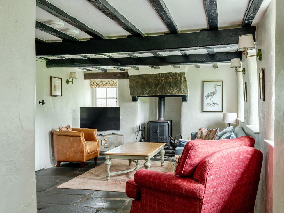 A living room with a sofa, armchair and coffee table at Hullet Hall at the Graythwaite Estate near Hawkshead