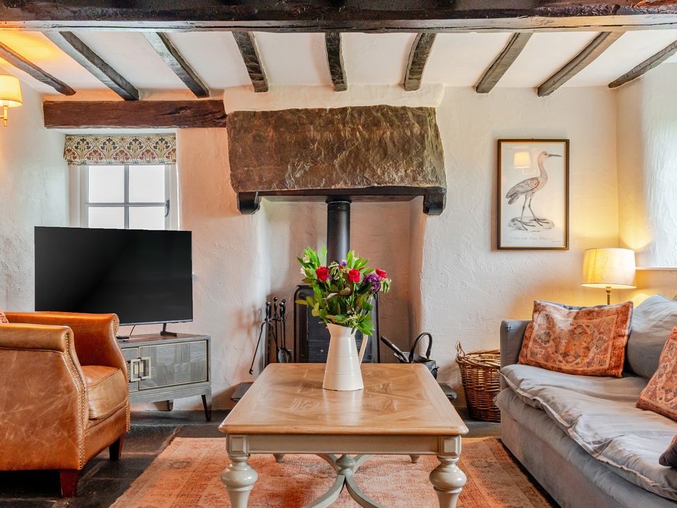 A living room with a television and a vase on a table at Hullet Hall at the Graythwaite Estate near Hawkshead