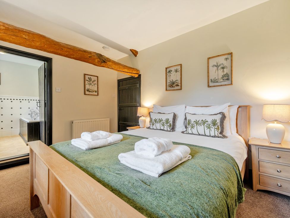 A bedroom with a bed and towels at Hullet Hall at the Graythwaite Estate near Hawkshead