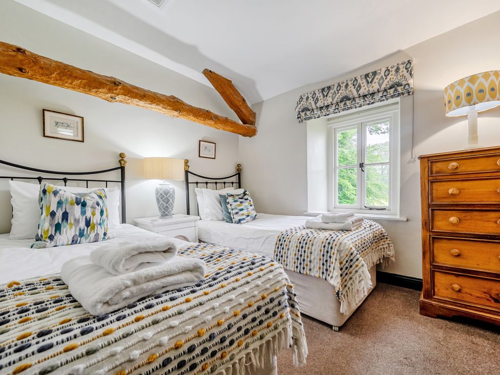 A bedroom with two beds and a window at Hullet Hall at the Graythwaite Estate near Hawkshead
