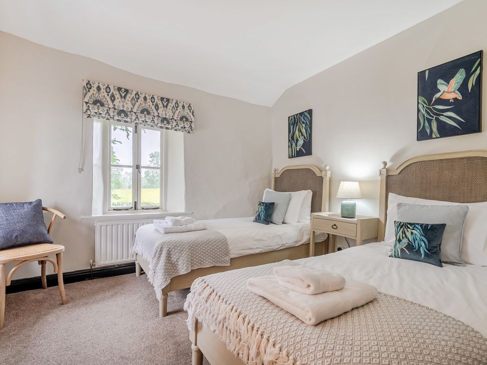 A bedroom with twin beds and a window at Hullet Hall at the Graythwaite Estate near Hawkshead