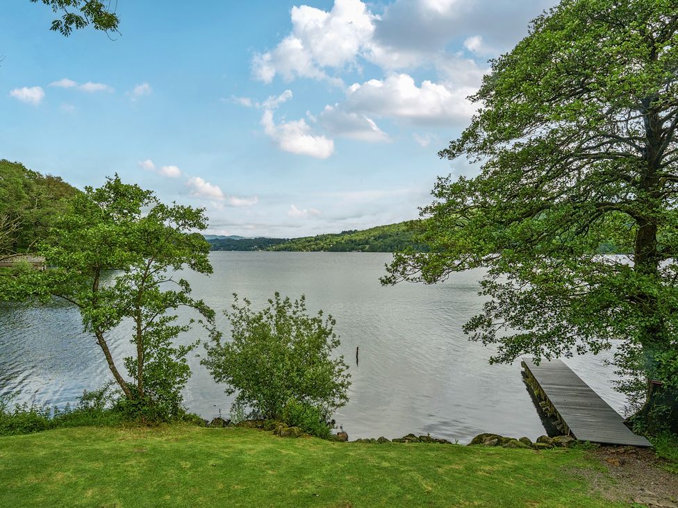 A view of a lake with trees and a dock at Hullet Hall at the Graythwaite Estate near Hawkshead