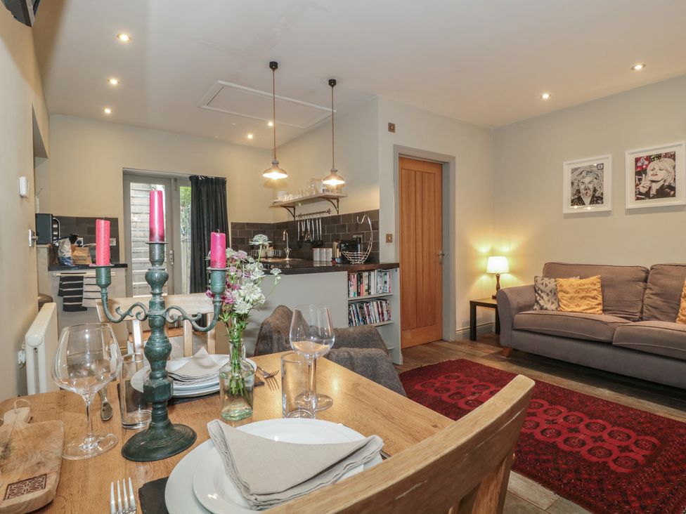 A kitchen and dining area with a table and sofa at The Stable in Deepdean near Ross-on-Wye