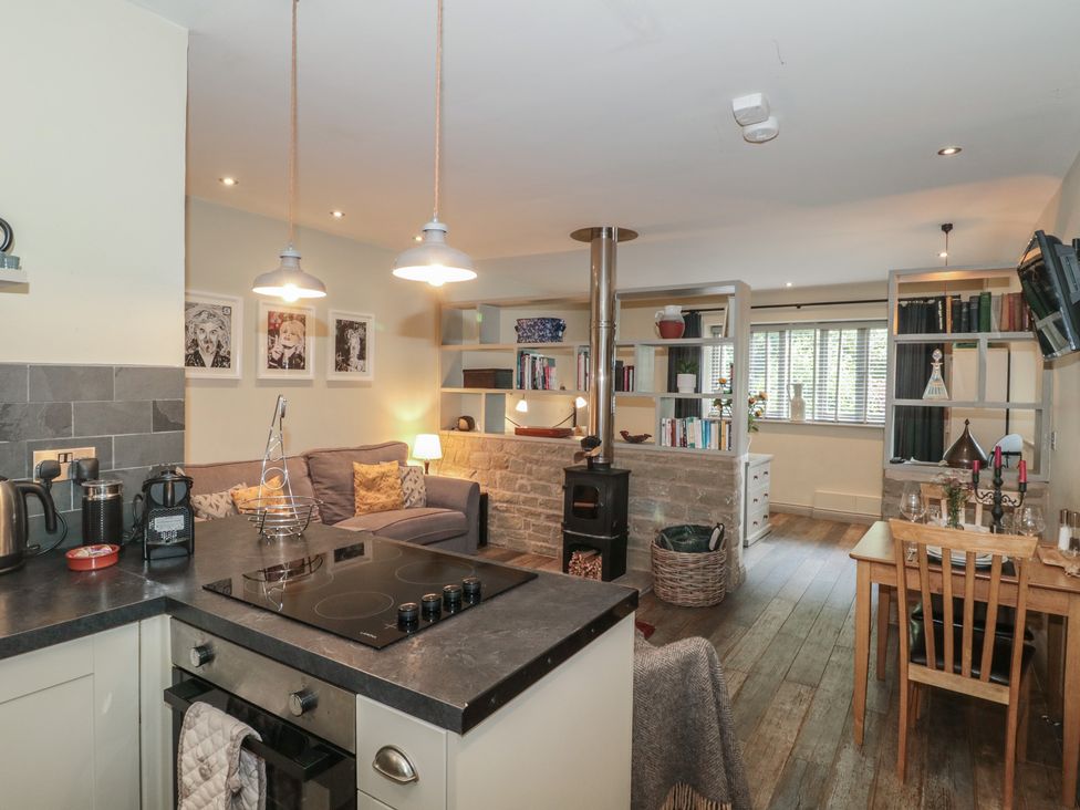 A living room with a couch and bookshelf at The Stable in Deepdean near Ross-on-Wye