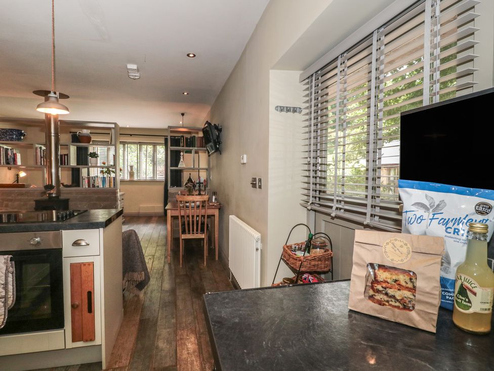 A kitchen with an oven and seating area at The Stable in Deepdean near Ross-on-Wye