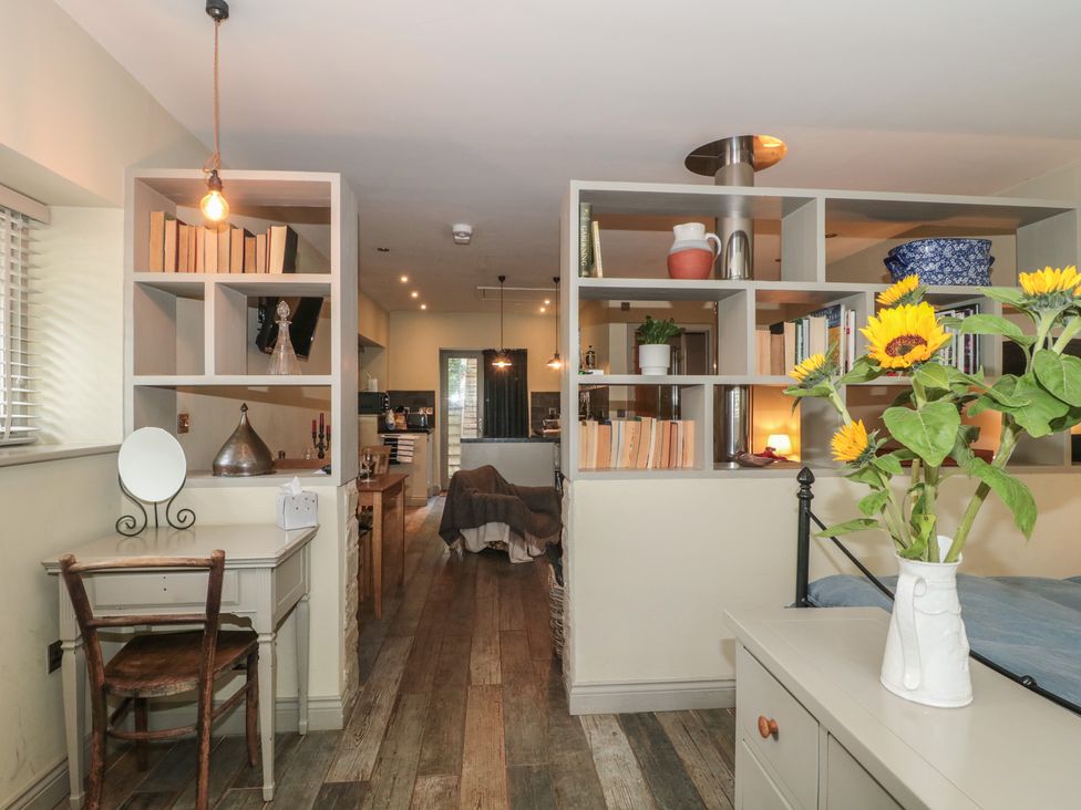 A kitchen with shelves and a dining area at The Stable in Deepdean near Ross-on-Wye