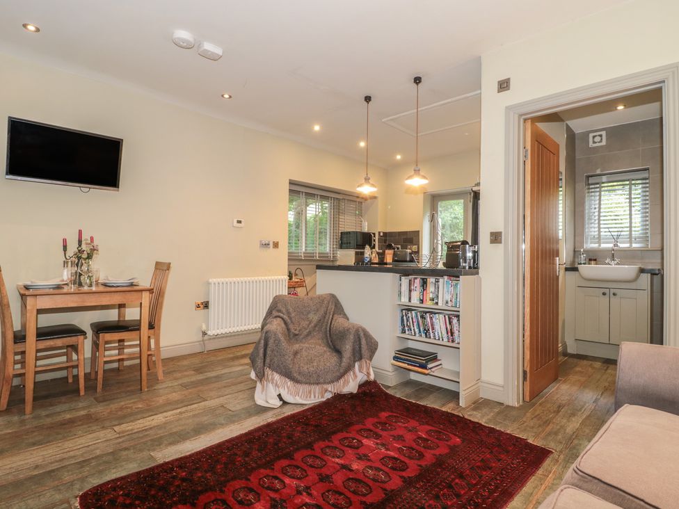 A living room with a dining table and kitchen counter at The Stable Deepdean near Ross-on-Wye