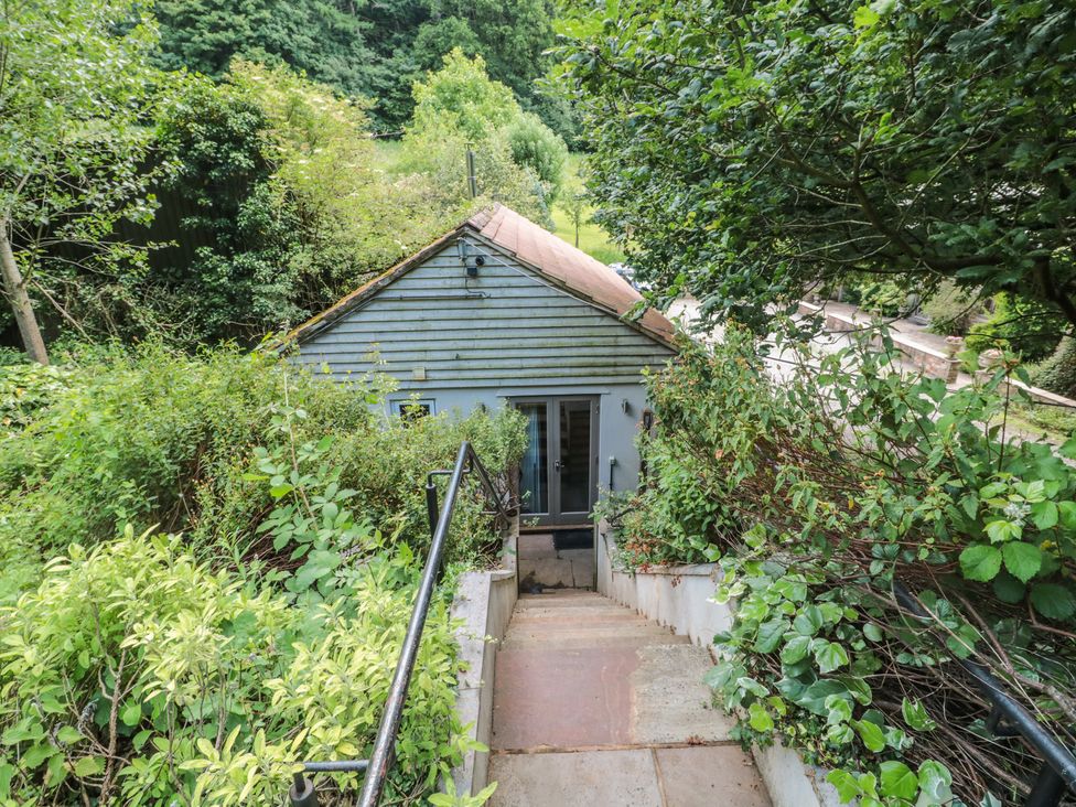 A view of a building surrounded by greenery at The Stable in Deepdean near Ross-on-Wye