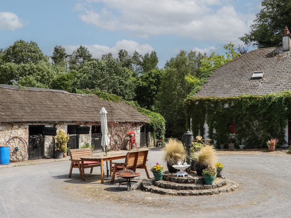 A courtyard with a table and chairs near a barn at Mrs Delaney's Loft Ardfinnan near Clonmel County Tipperary