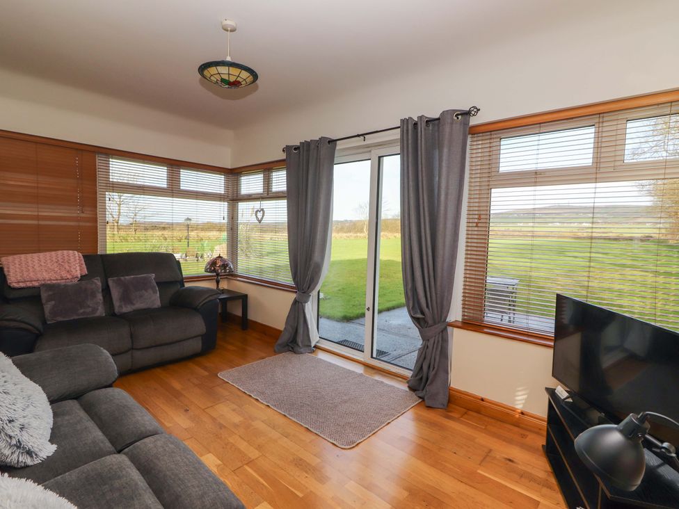 A living room with a sofa and television at Moybella Lodge in Lisselton near Ballybunion, County Kerry