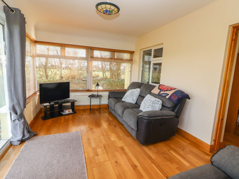 A living room with a sofa and television at Moybella Lodge in Lisselton near Ballybunion, County Kerry