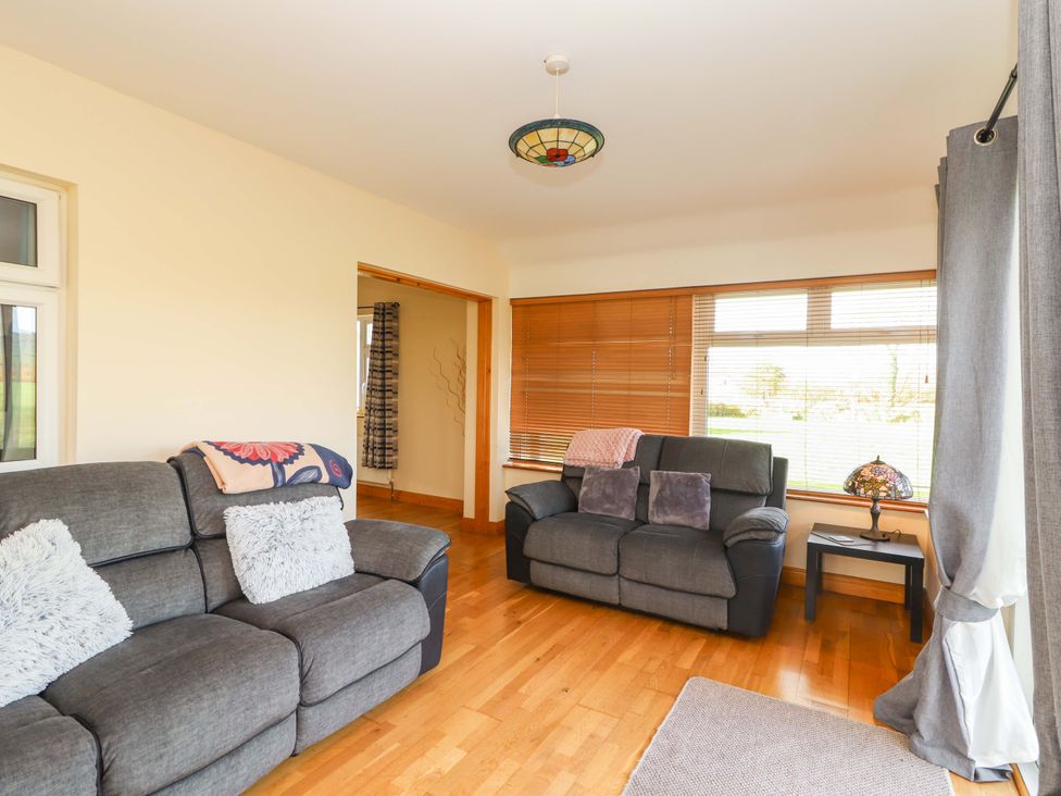 A living room with sofas and a lamp at Moybella Lodge in Lisselton near Ballybunion, County Kerry
