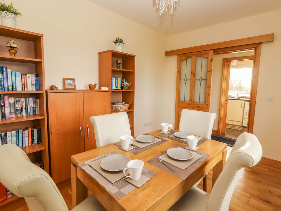A dining room with a table set for a meal at Moybella Lodge in Lisselton near Ballybunion, County Kerry