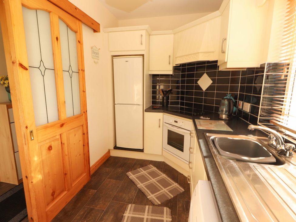 A kitchen with appliances and cabinets at Moybella Lodge in Lisselton near Ballybunion, County Kerry