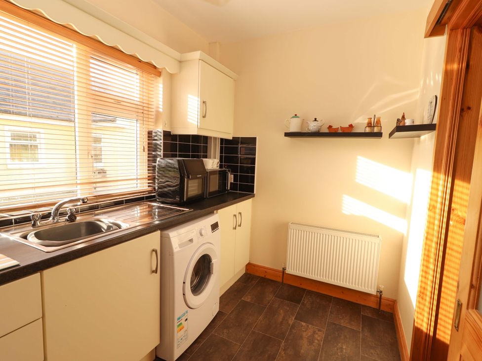 A kitchen with a sink and washing machine at Moybella Lodge in Lisselton near Ballybunion, County Kerry