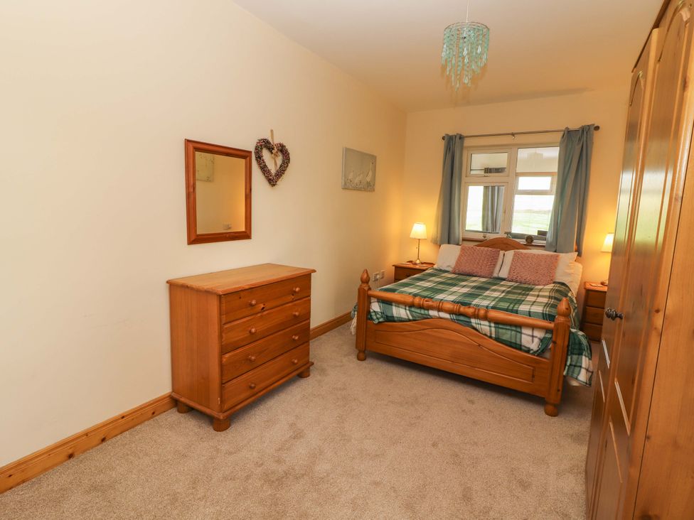 A bedroom with wooden furniture at Moybella Lodge in Lisselton near Ballybunion, County Kerry