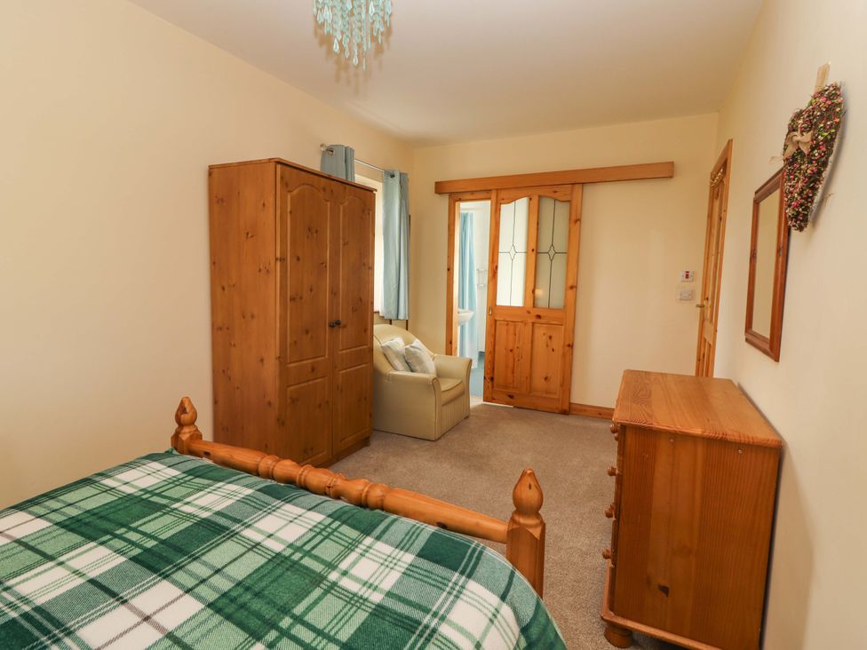 A bedroom with a bed, wardrobe and sofa at Moybella Lodge in Lisselton near Ballybunion, County Kerry