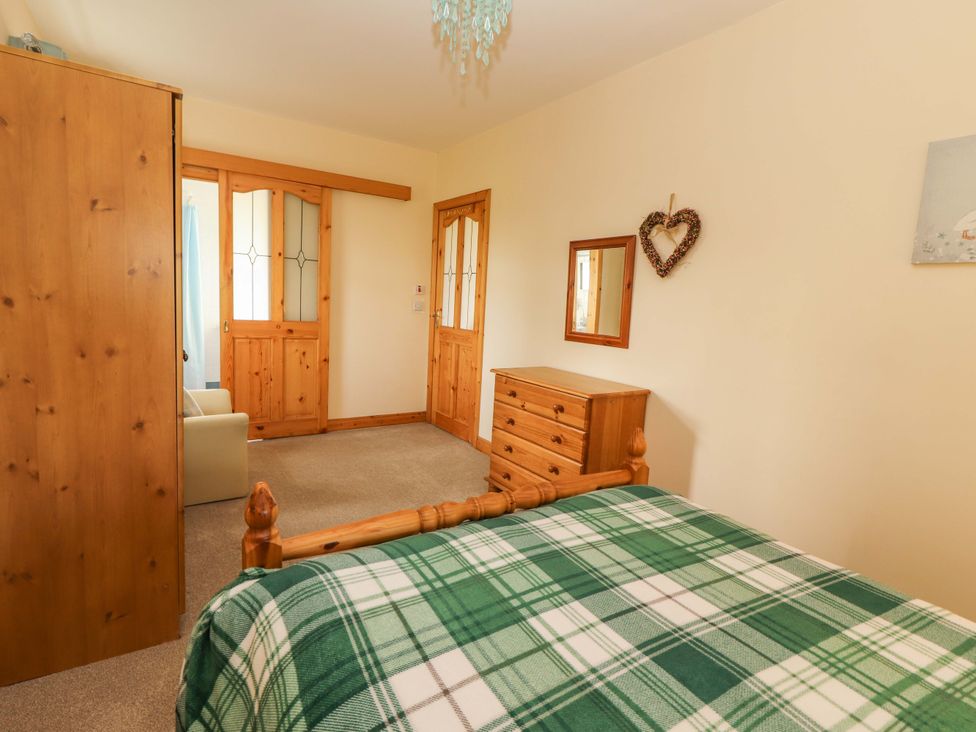 A bedroom with a bed and a wardrobe at Moybella Lodge, Lisselton near Ballybunion, County Kerry