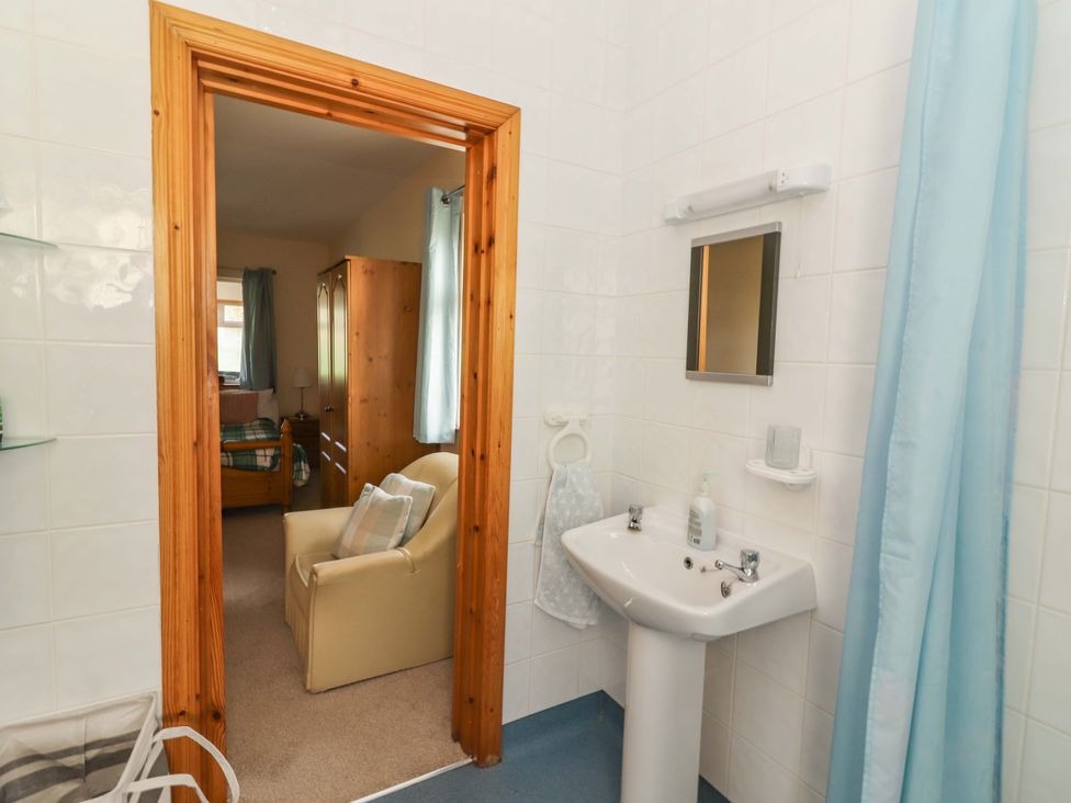 A bathroom with a sink and mirror leading to a bedroom at Moybella Lodge in Lisselton near Ballybunion, County Kerry
