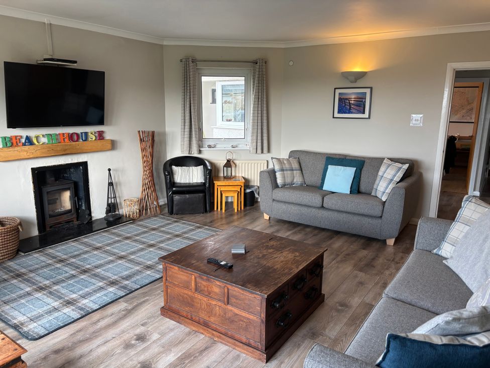 A living room with a television and sofa at The Beach House Trearddur Bay