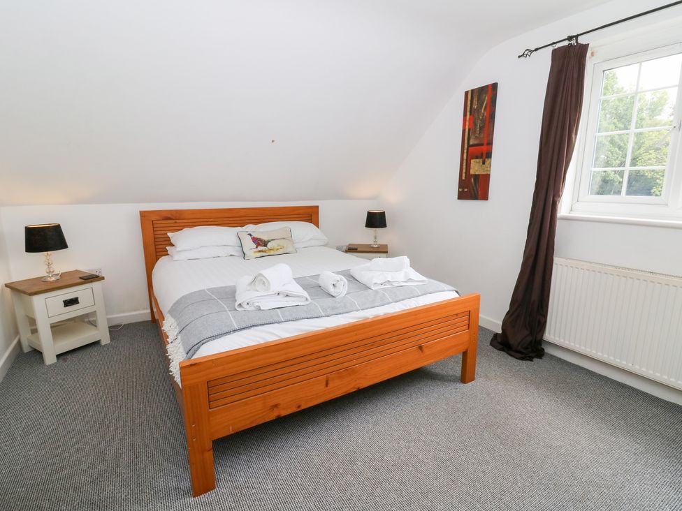 A bedroom with a bed and bedside table at Cariad Cottage in Cross Inn