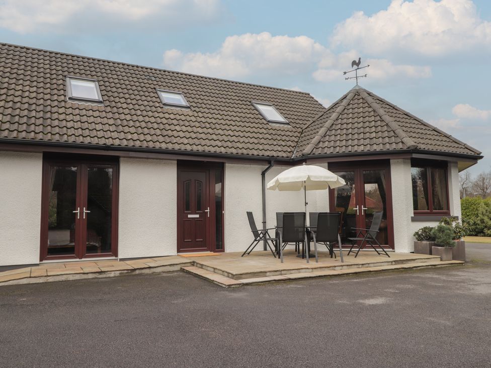An outdoor area with a table and chairs at Little Chestnut in Muir of Ord