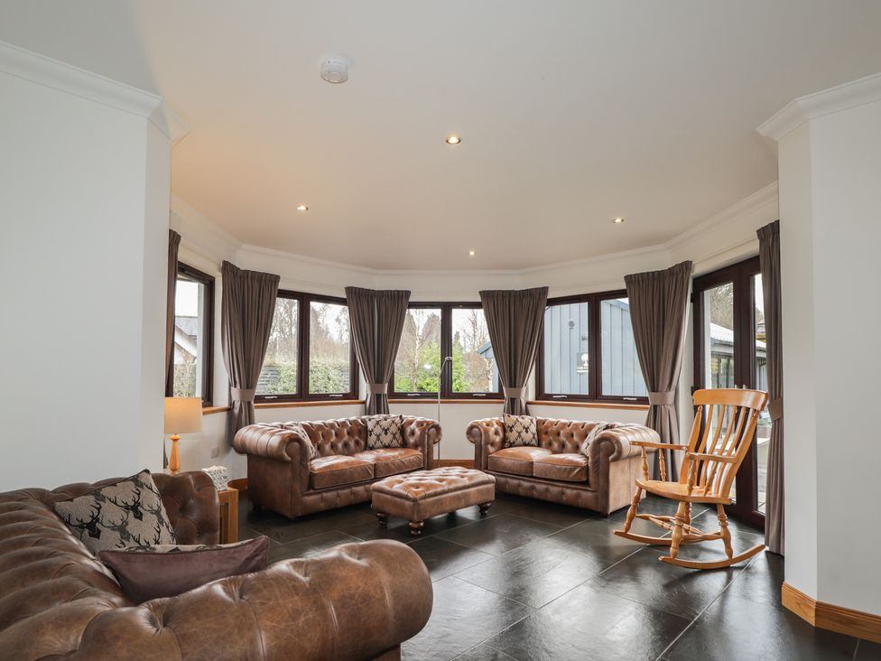 A snug with leather sofas and a rocking chair at Little Chestnut in Muir of Ord