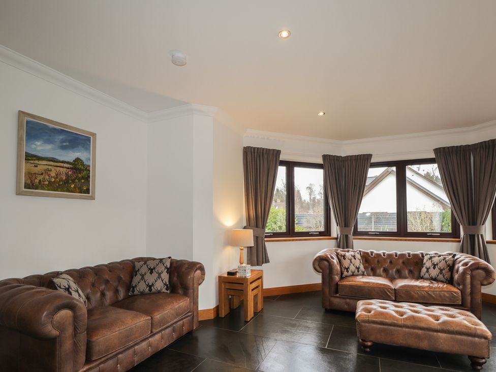 A living room with sofas and a lamp at Little Chestnut in Muir of Ord