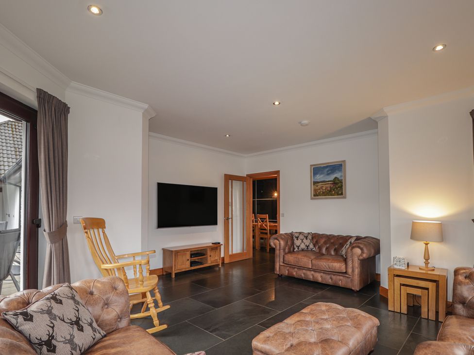 A living room with a sofa and television at Little Chestnut in Muir of Ord