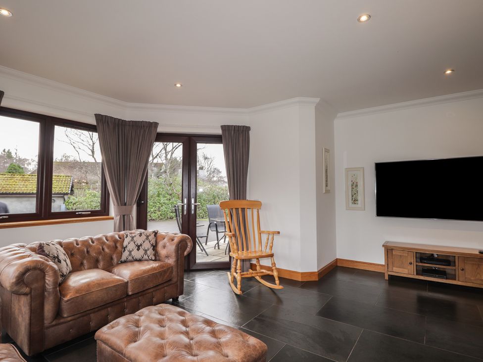 A living room with a sofa and a rocking chair at Little Chestnut in Muir of Ord