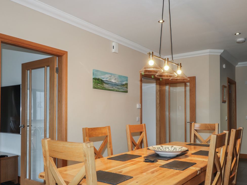 A dining room with a wooden table and chairs at Little Chestnut in Muir of Ord